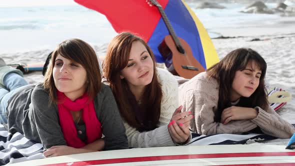 Three girls lying on the beach