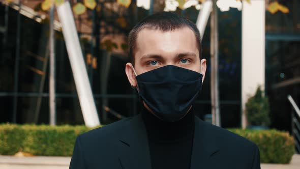 Close Up of Face of Young Handsome Businessman in Medical Mask Walking Straight To Camera. Portrait