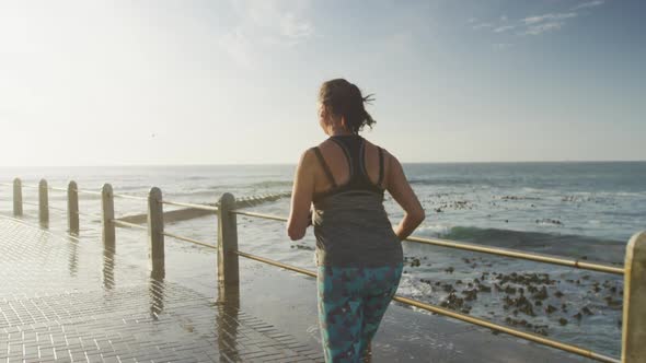 Rear view of senior woman running on a promenade