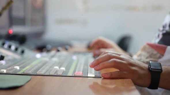 Close-up of a man sitting at a TV control panel for production and broadcasting