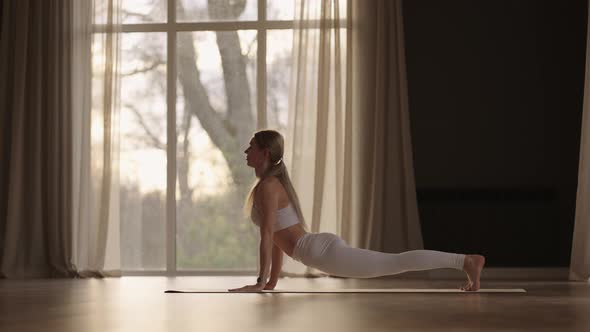 A Young Woman Exercises Performing Exercises From Yoga in Slow Motion in Sunlight