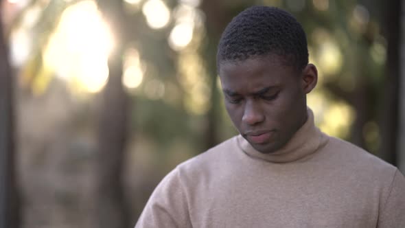 Nervous young man fumbling on his turtleneck