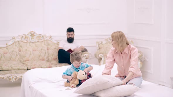 Happy Family Playing with Pillows in Bed.