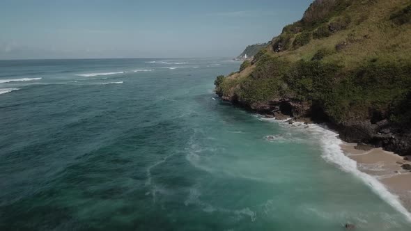 Aerial View of Tropical Beach with Azure Blue Water and Foaming Ocean Waves