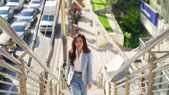 4K Asian business woman walking up staircase at railway station