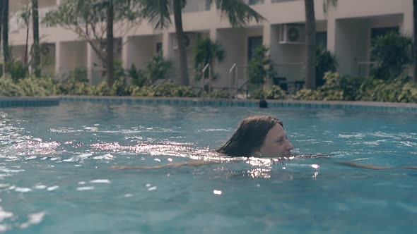 Graceful Lady Swims in Empty Pool at Resort Slow Motion