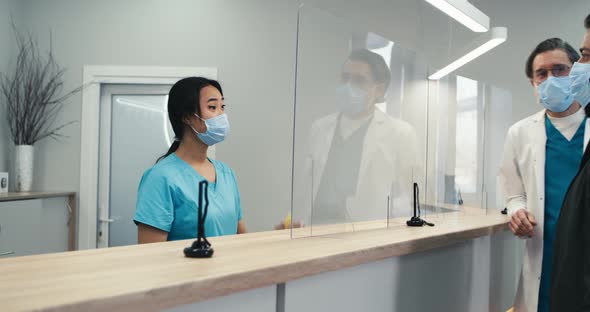 Asian Receptionist Helping Patient to Get Appointment