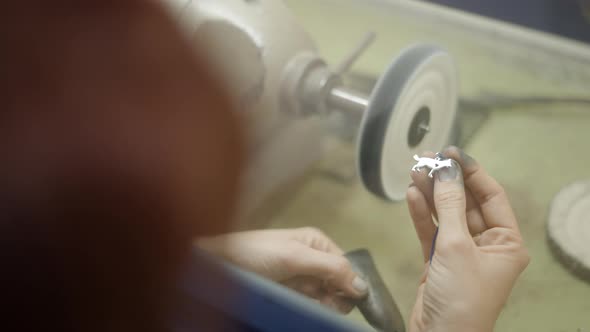 Jeweler Hands With A Piece Of Metal Accessory On Dust Box Acrylic Cover For Polishing Machine