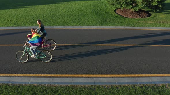 Aerial Side View of Young Lgbt Couple Riding Bikes