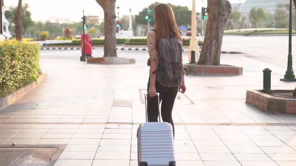 Young Woman with Baggage on the Street in Asia