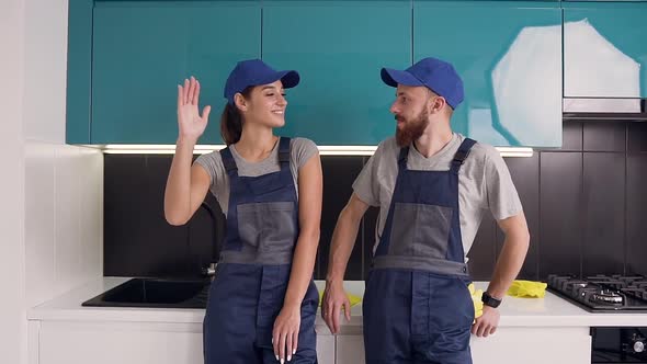 Attractive Workers in the Blue Uniform Giving Each Other High Five After Successful Cleaning