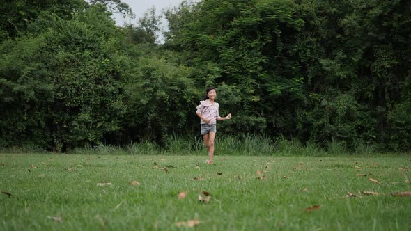 Slow motion, Happy little girl running and smiling in the park