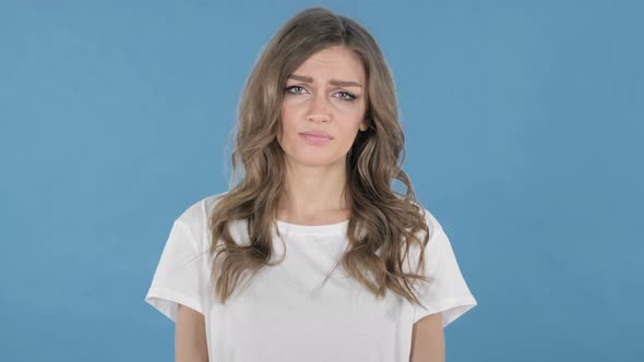 Sad Upset Young Girl Isolated on Blue Background