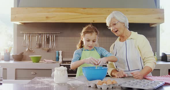 Little girl break egg in bowl and grandma happily applauding 4K 4k