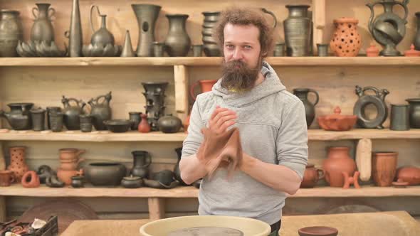 Pottery master wipes his hands after working on a clay pot