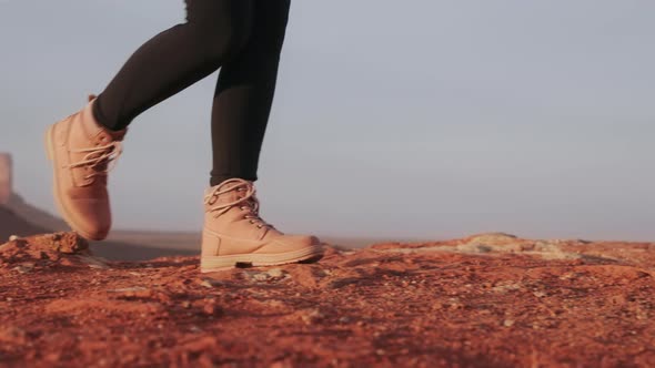 Camera Following Female Legs in Hiking Boots Walking By Red Desert Nature Park