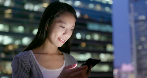 Woman use of smart phone at outdoor in the evening