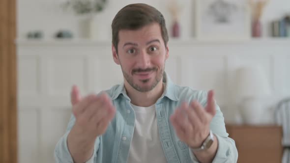 Portrait of Young Man Pointing at the Camera and Inviting