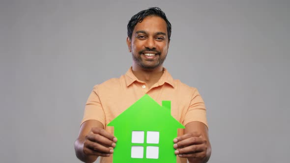 Smiling Indian Man Holding Green House Icon