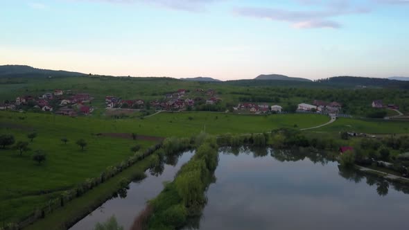 Aerial moving up while tilting slowly down, wide shot of a fishing resort with a town in the backgro