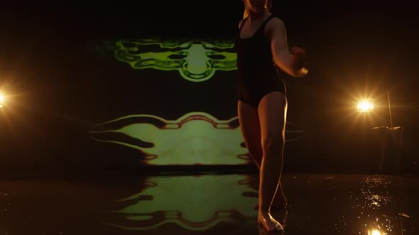 Artistic Young Woman Performing Against Dark Animated Background in Studio