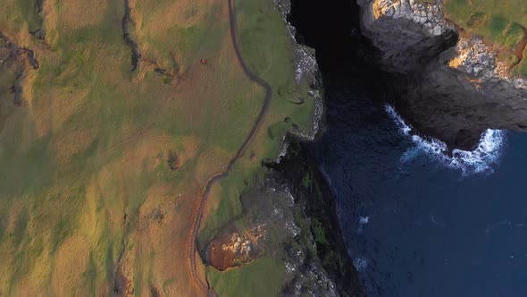 Top Aerial View of Huge Cliff of Faroe Islands Drone Flying Over a V Cove in Sunset