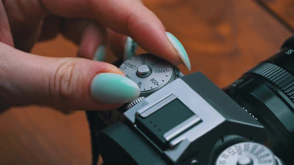Girl's Hands are Spinning the Iso Wheel on a Vintage Camera Closeup