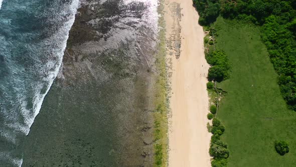 aerial top down view of empty white sand beach at Nyang Nyang in Uluwatu Bali on sunny day