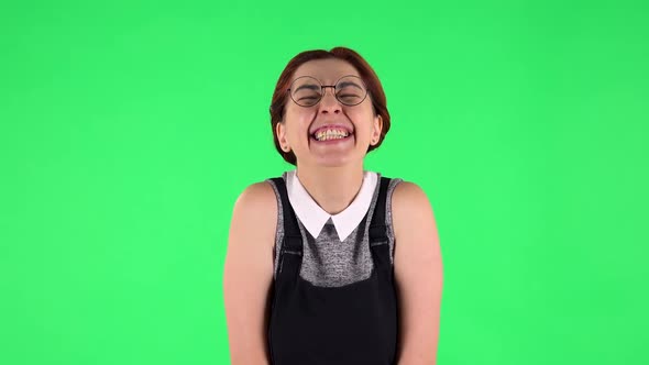 Portrait of Funny Girl in Round Glasses Is Rejoicing. Green Screen
