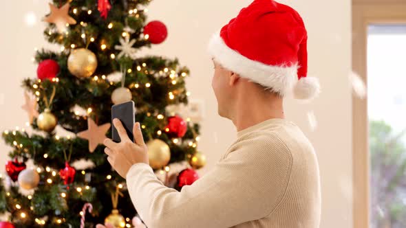 Man with Phone Having Video Call at Christmas Tree