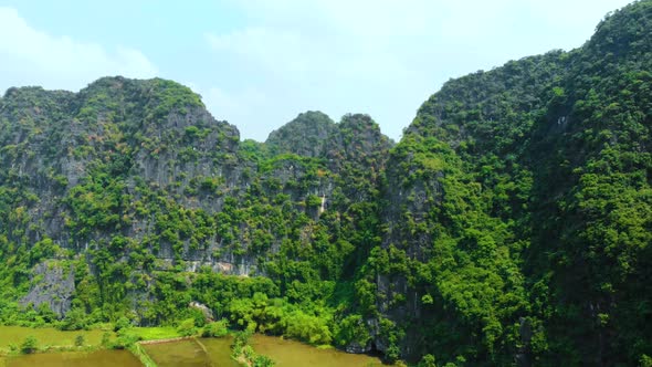 Aerial: North Vietnam karst landscape at sunset, drone view of Ninh Binh region, tourist destination