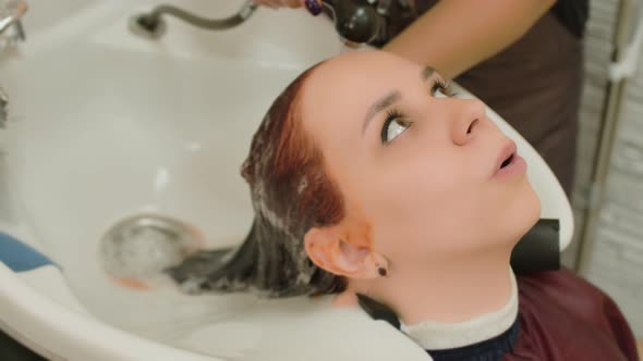 A Woman Washes Her Hair in a Beauty Salon After Dyeing Her Hair