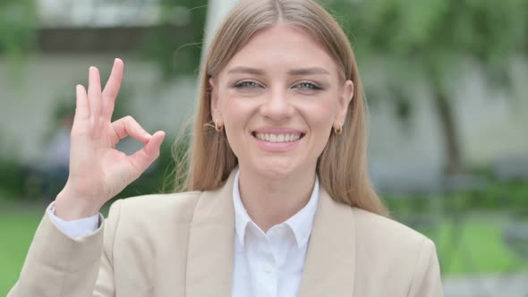 Outdoor Portrait of Thumbs Down Gesture By Young Businesswoman