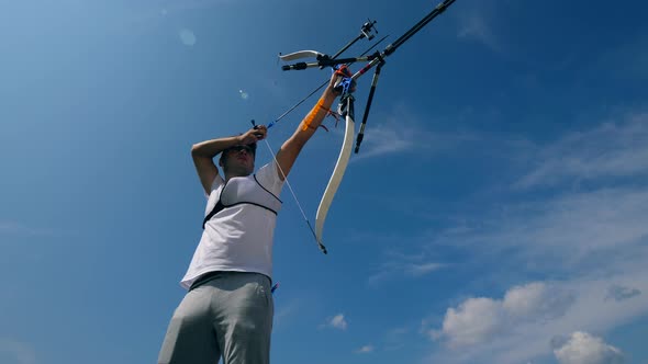 A Man Training with a Modern Bow on a Range.