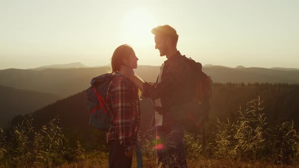 Loving Girl and Guy Spending Time Together in Mountains at Sunset
