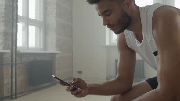 Sportsman Using Smartphone Between Sets