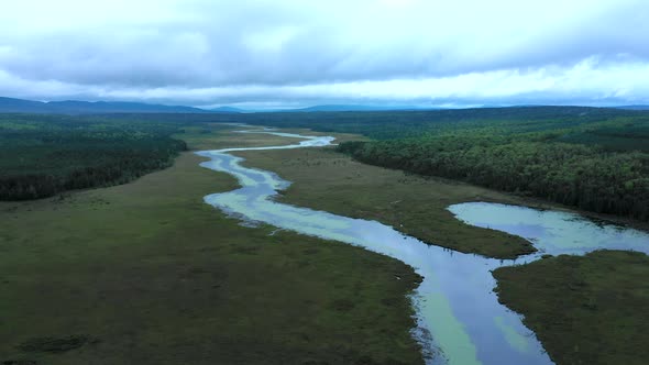 Aerial shot pushing out over the waters of Shirley Bog winding through the Maine countryside surroun