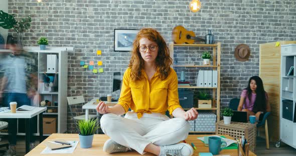 Zoom-in Time Lapse of Pretty Girl Meditating on Desk in Office Enjoying Break