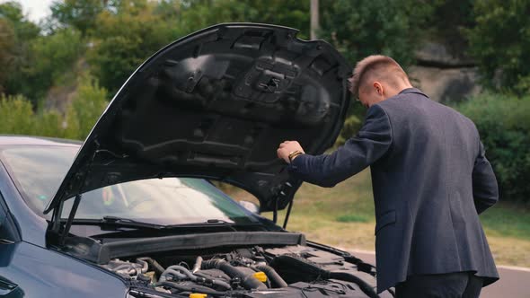 Man Opens the Hood of the Car