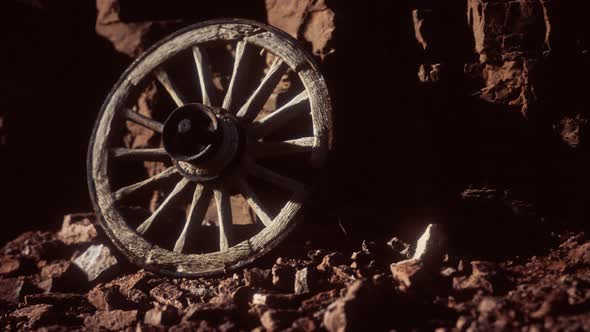 Old Wooden Cart Wheel on Stone Rocks