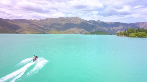 Aerial. Epic shot of a jet ski racing on a crystal clear water. Adult male enjoying summer vacation