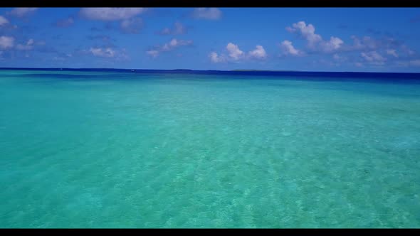 Aerial drone shot sky of tranquil coastline beach holiday by transparent sea with bright sandy backg