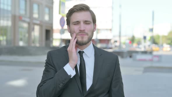 Portrait of Businessman Having Toothache Outdoor