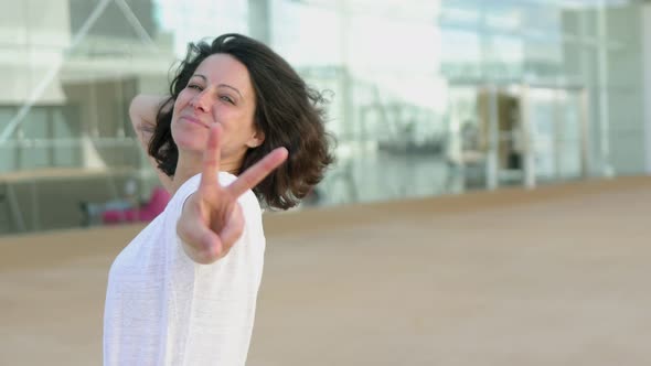 Beautiful Brunette Lady Showing Peace Sign Outdoor