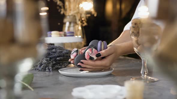 Female Chef Putting Macaroons Into the Plate