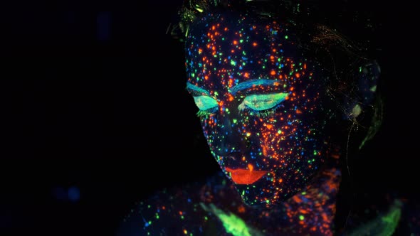 Close-up Portrait in Ultraviolet Light. Face Painted with Glow in the Dark Paint