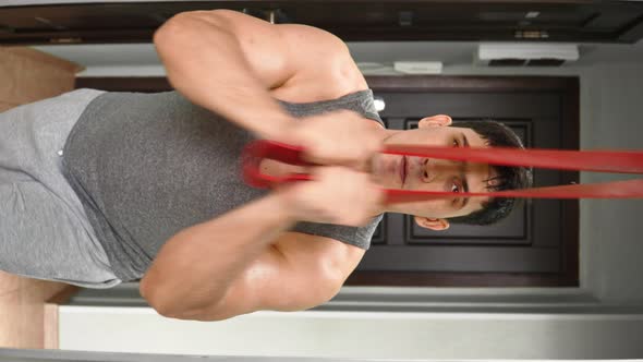 Athletic Man Exercising with Fitness Rubber Bands at Home