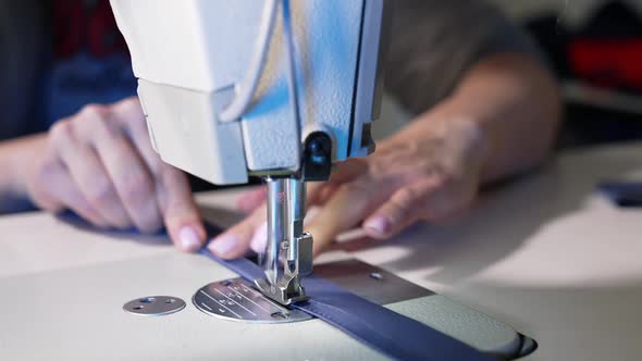 Tailor working with sewing machine at fashion design workshop