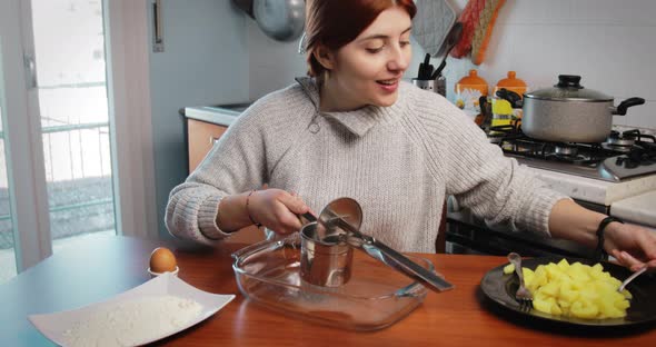 Girl is Mashing Boiled Potatoes for the Preparation of Dumplings and Croquettes