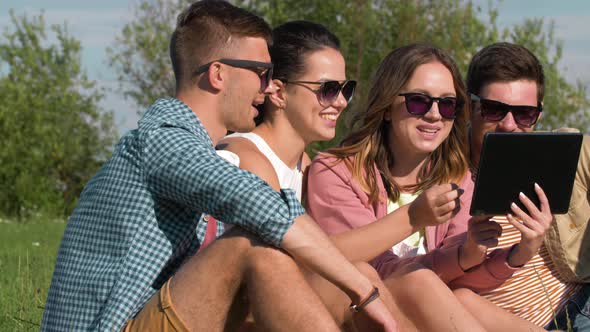 Smiling Friends with Tablet Pc at Summer Park 